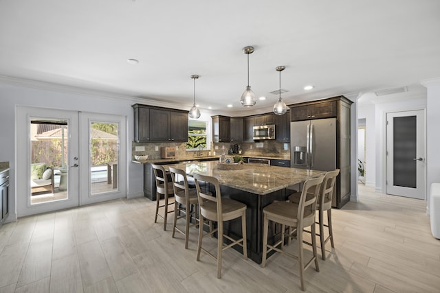 kitchen featuring appliances with stainless steel finishes, dark stone countertops, dark brown cabinets, decorative light fixtures, and french doors