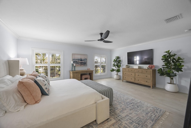 bedroom featuring multiple windows, ornamental molding, ceiling fan, and light hardwood / wood-style flooring