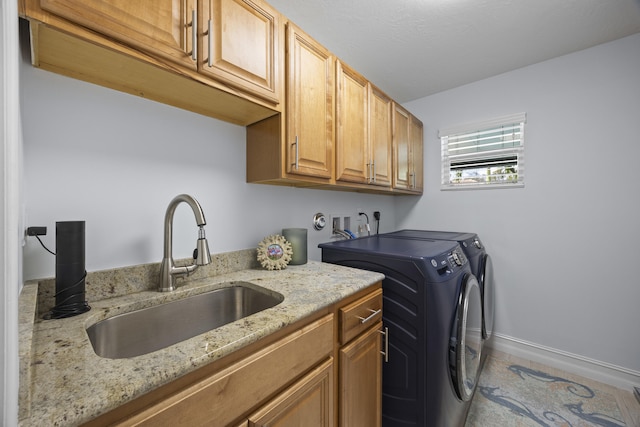 washroom featuring sink, cabinets, and independent washer and dryer