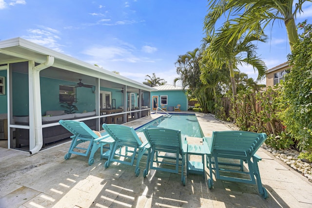 view of pool featuring a sunroom, ceiling fan, and a patio area