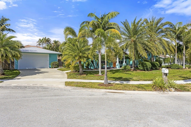 view of property hidden behind natural elements with a garage and a front lawn