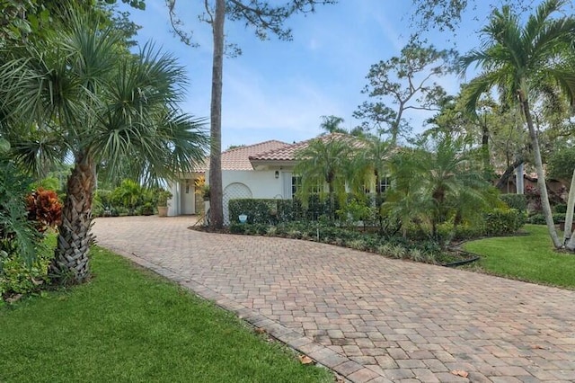 mediterranean / spanish home featuring a front lawn