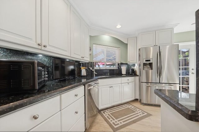 kitchen with sink, white cabinets, backsplash, stainless steel appliances, and a healthy amount of sunlight