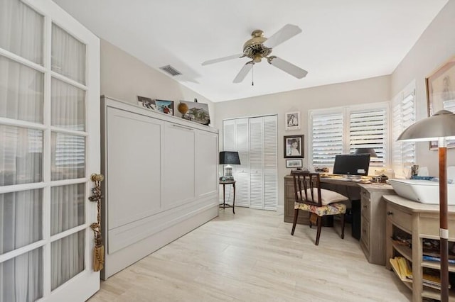 home office with lofted ceiling, ceiling fan, and light hardwood / wood-style flooring