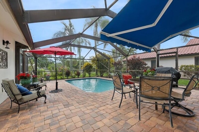 view of pool with a patio area and glass enclosure