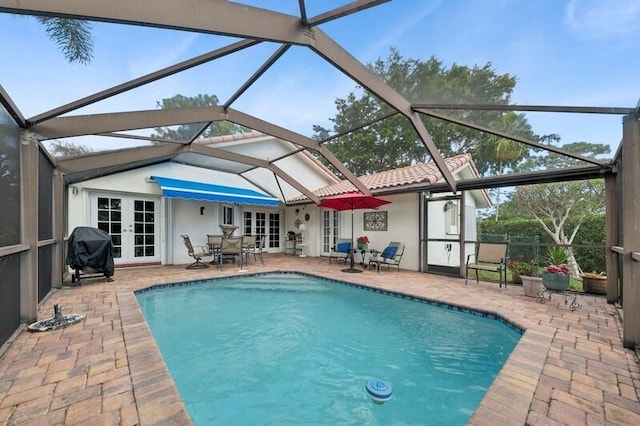 view of pool with french doors, a grill, a patio, and glass enclosure