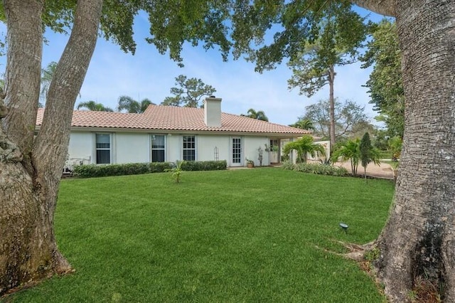 rear view of house featuring a yard