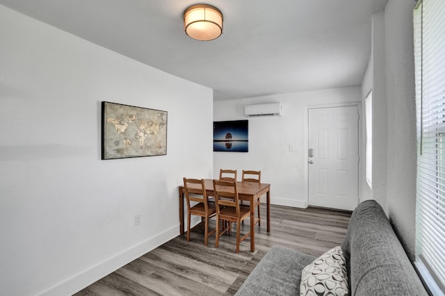 dining area with an AC wall unit and hardwood / wood-style floors