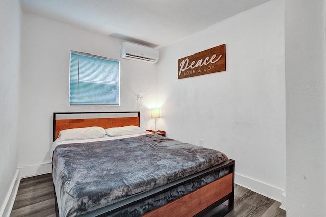 bedroom with dark wood-type flooring and a wall unit AC