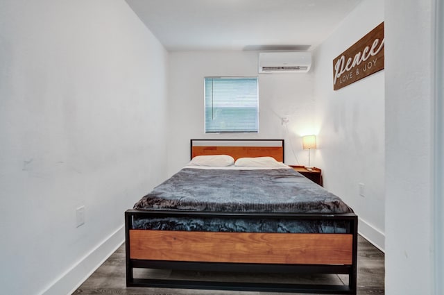 bedroom with dark hardwood / wood-style floors and a wall mounted air conditioner