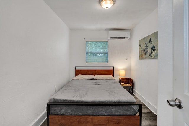 bedroom featuring dark wood-type flooring and an AC wall unit