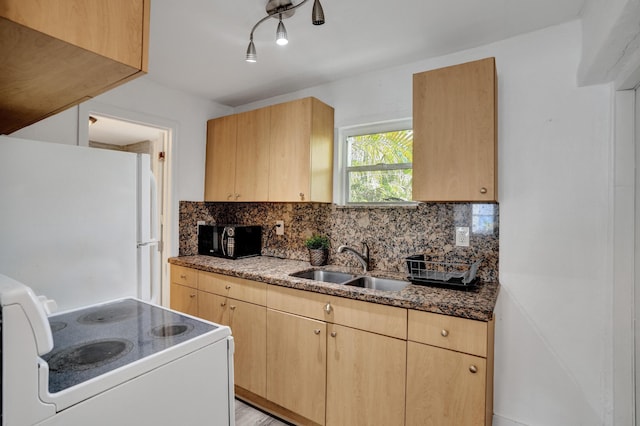 kitchen with light brown cabinetry, sink, white appliances, and decorative backsplash