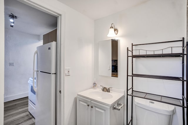 bathroom with vanity, hardwood / wood-style floors, and toilet