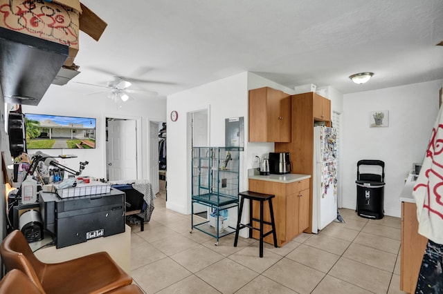 kitchen with white refrigerator, ceiling fan, and light tile patterned floors