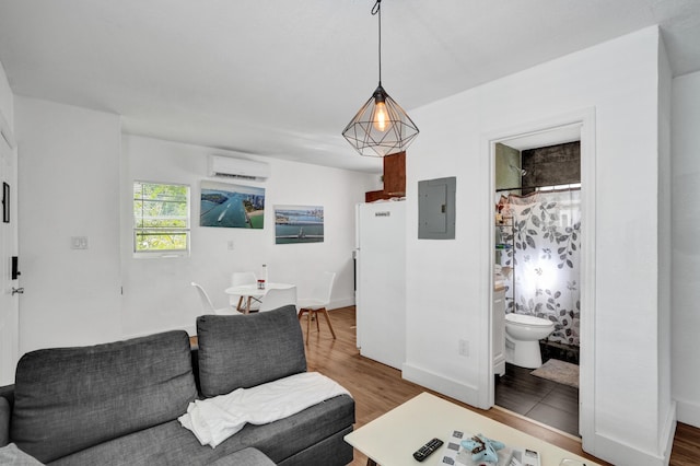 living room featuring an AC wall unit, hardwood / wood-style floors, and electric panel