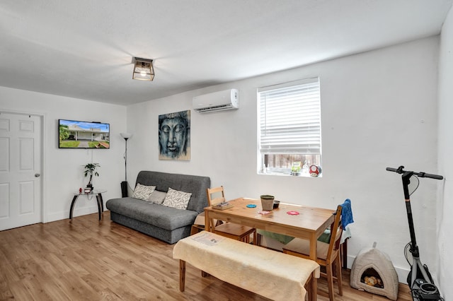 living room featuring a wall mounted air conditioner and light wood-type flooring