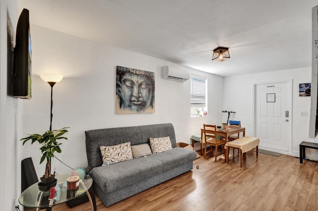 living room with a wall unit AC and light wood-type flooring