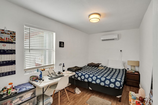 bedroom with wood-type flooring and an AC wall unit