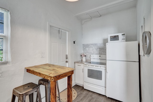 kitchen featuring white cabinetry, decorative backsplash, white appliances, and light hardwood / wood-style floors