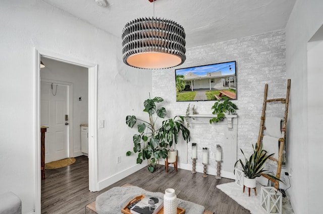 interior space featuring dark wood-type flooring and brick wall