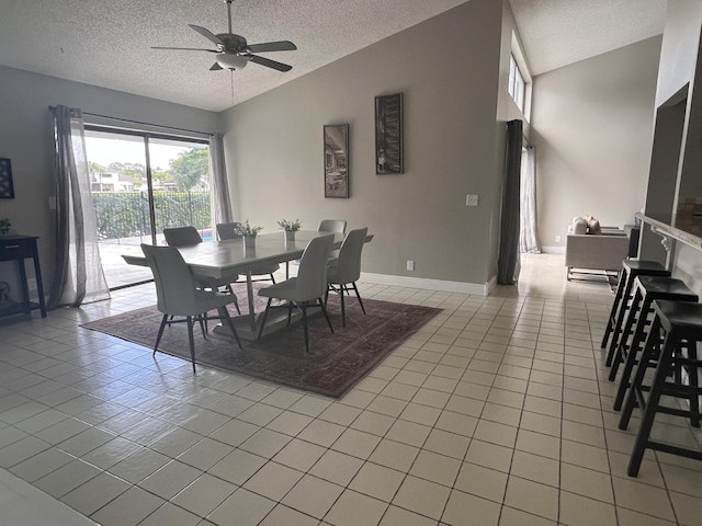 tiled dining area with vaulted ceiling, ceiling fan, and a textured ceiling