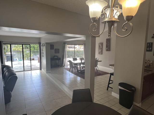 dining space with a notable chandelier, light tile patterned floors, and a healthy amount of sunlight