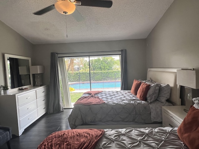 bedroom featuring lofted ceiling, ceiling fan, access to exterior, a textured ceiling, and dark hardwood / wood-style flooring