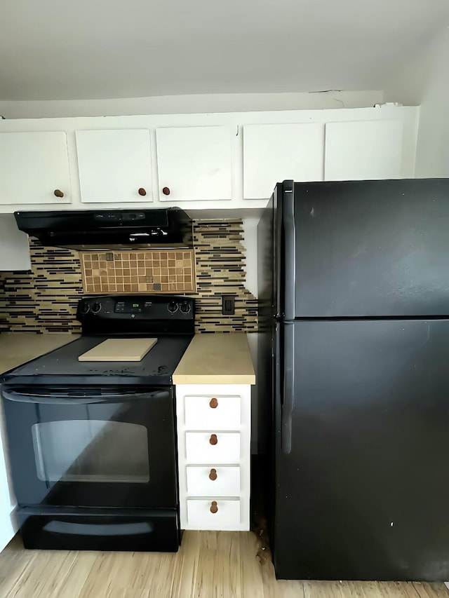 kitchen with backsplash, ventilation hood, black appliances, and white cabinets