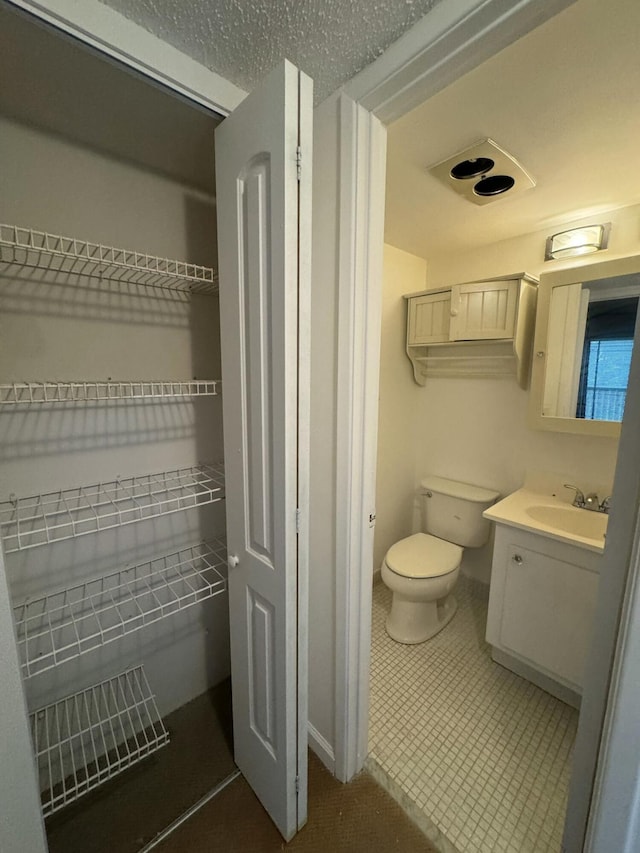 bathroom with vanity, tile patterned floors, and toilet