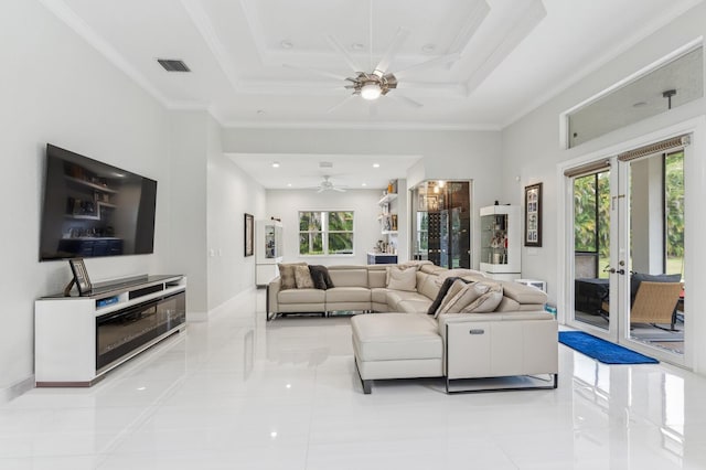 living room featuring a tray ceiling, ornamental molding, and a high ceiling