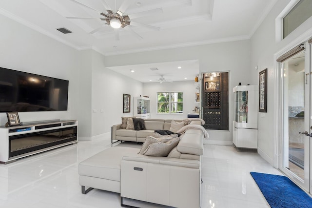 living room with ceiling fan, ornamental molding, and a raised ceiling