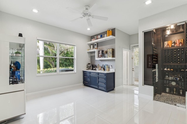 interior space featuring ceiling fan, blue cabinets, and light tile patterned floors