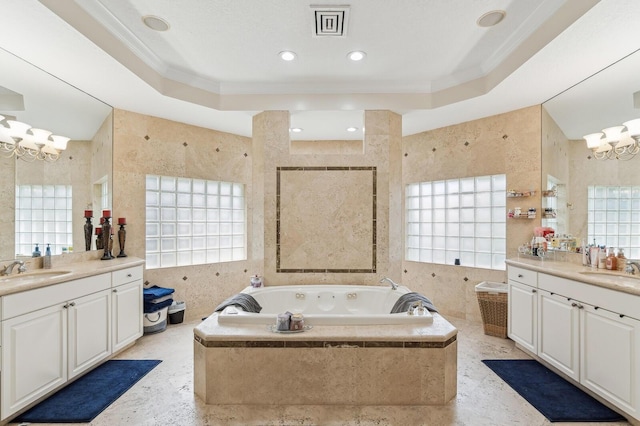 bathroom with tile walls, a chandelier, a raised ceiling, and a healthy amount of sunlight