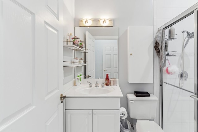 bathroom featuring vanity, toilet, and a shower with shower door