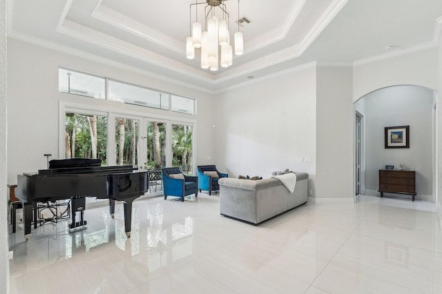 living room featuring a raised ceiling, a high ceiling, a notable chandelier, and ornamental molding