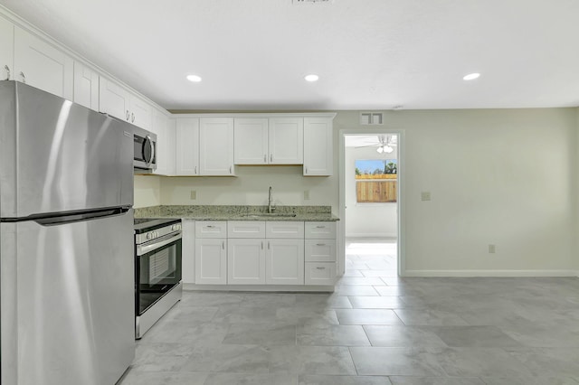 kitchen featuring white cabinetry, sink, ceiling fan, light stone counters, and stainless steel appliances