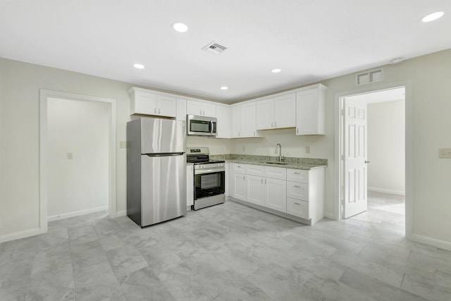 kitchen featuring appliances with stainless steel finishes, sink, and white cabinets