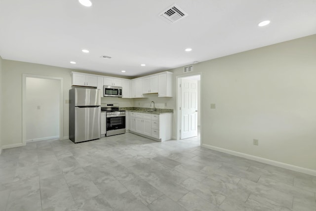 kitchen with white cabinetry, sink, light stone counters, and appliances with stainless steel finishes