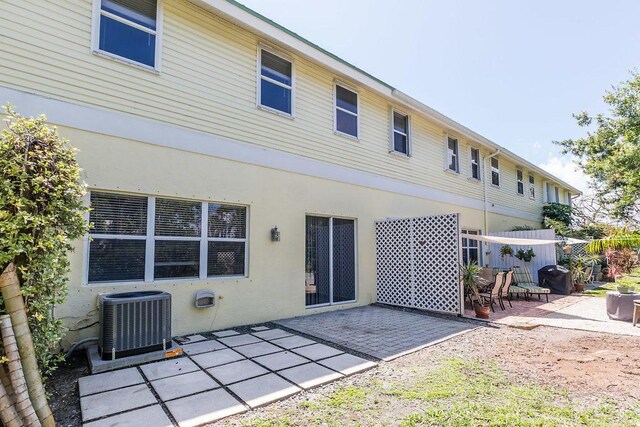 rear view of house featuring a patio and cooling unit