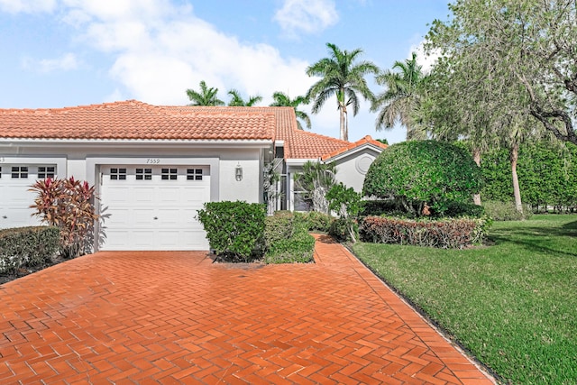 mediterranean / spanish-style house featuring a garage and a front yard