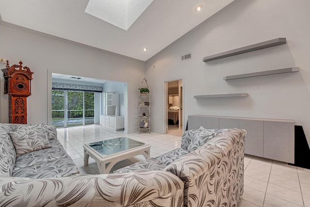 living room featuring light tile patterned floors, high vaulted ceiling, and a skylight