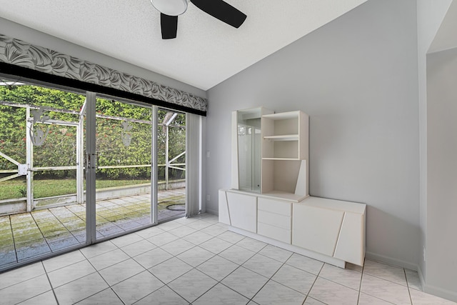 unfurnished room featuring ceiling fan, lofted ceiling, a textured ceiling, and light tile patterned floors