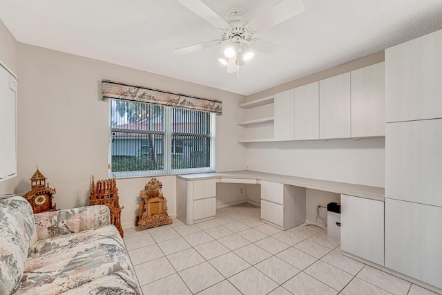 office area with light tile patterned floors, built in desk, and ceiling fan