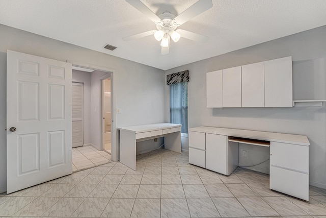 interior space featuring light tile patterned flooring, ceiling fan, and a textured ceiling