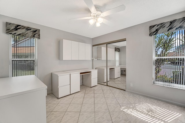 clothes washing area with a textured ceiling, washing machine and dryer, and ceiling fan