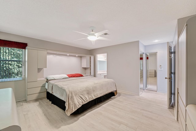 bedroom featuring ceiling fan, a textured ceiling, and light wood-type flooring