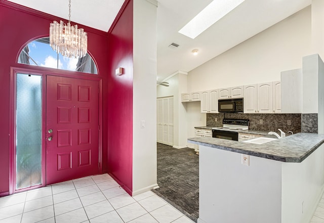 tiled foyer with high vaulted ceiling, a skylight, sink, and a notable chandelier