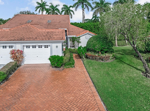 mediterranean / spanish-style home featuring a garage and a front lawn