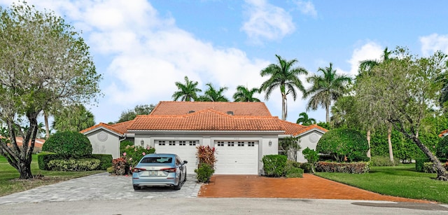 mediterranean / spanish home featuring a garage and a front yard