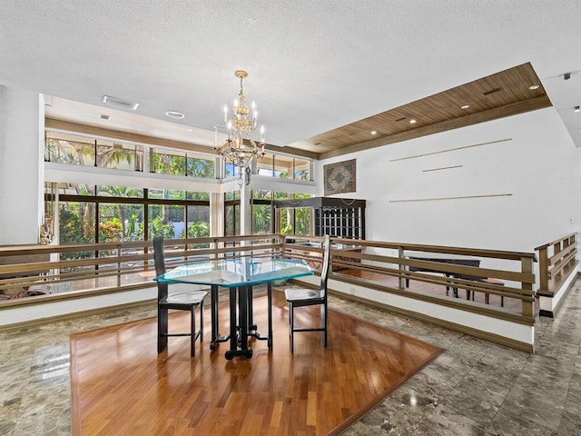 dining space with an inviting chandelier and a textured ceiling